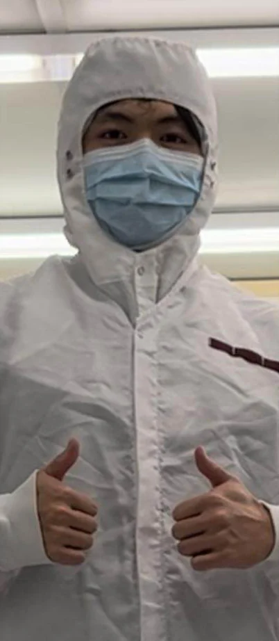Gabriel in a cleanroom suit, giving two thumbs up