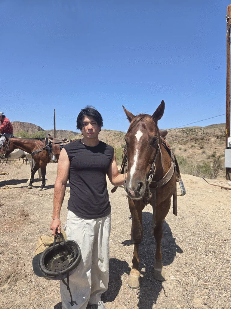 Gabriel standing with a horse on a desert trail